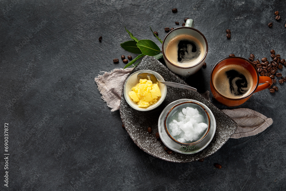 Bulletproof keto coffee. Ketogenic diet. Hot dring with coconut oil and ghee butter on dark background Bulletproof keto coffee. Ketogenic diet. Hot dring with coconut oil and ghee butter on dark background