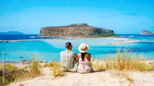Crete Greece Balos Lagoon Tourists relax at the crystal clear ocean of Balos Beach, a couple of men, and a woman visit the beach during a vacation in Greece photo