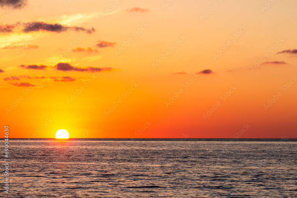travel to Georgia - setting sun in orange sky over Black Sea water in Batumi on autumn evening