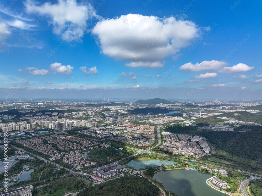 Aerial photography of green city, urban buildings, livable environment, blue sky and white clouds