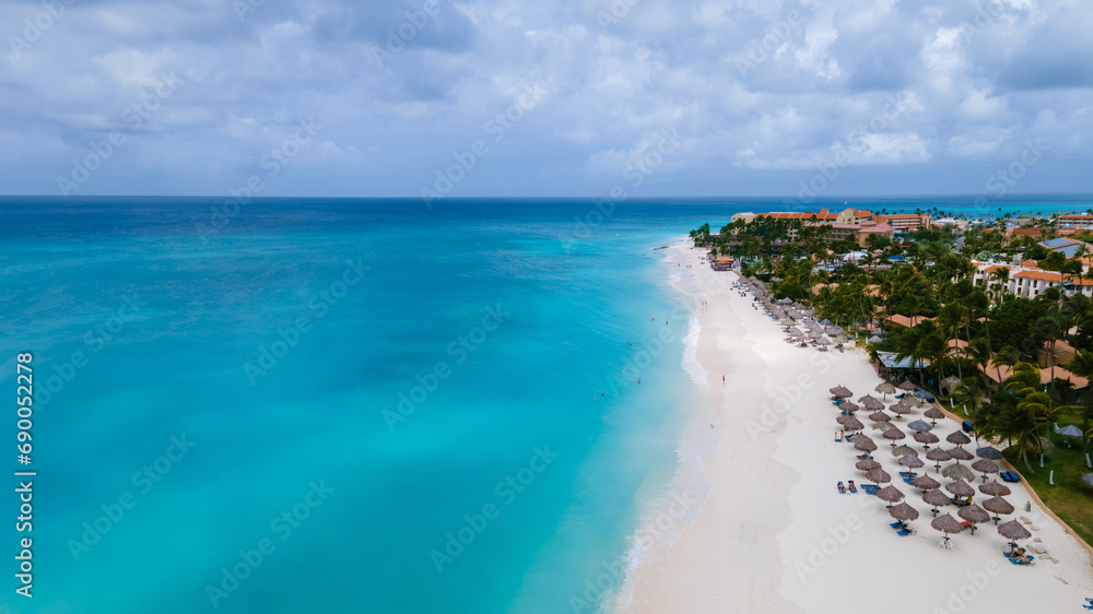 Eagle Beach Aruba with Palm Trees on the shoreline of Eagle Beach in Aruba, a aerial drone view at the beach on a sunny day