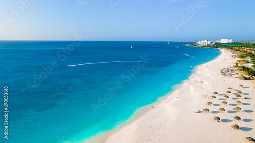 Eagle Beach Aruba with Palm Trees on the shoreline of Eagle Beach in Aruba, an aerial drone view at the beach on a sunny day photo
