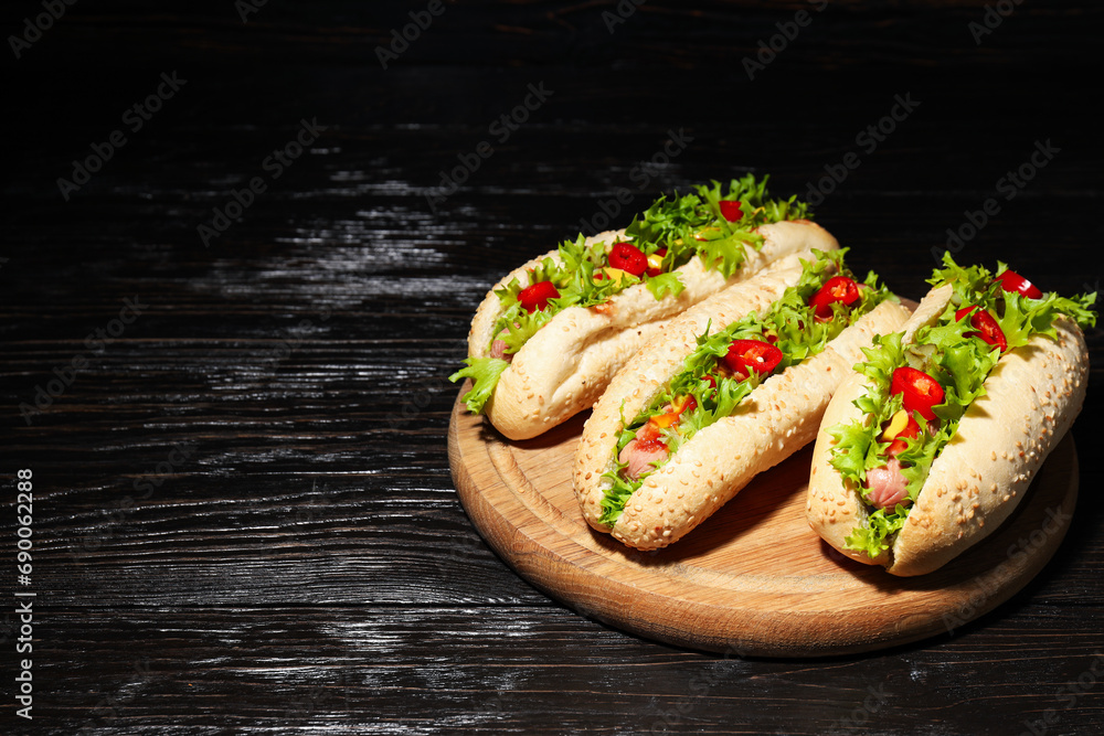 Hot dogs on board on wooden background, space for text Hot dogs on board on wooden background, space for text