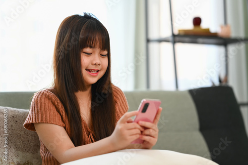 Cute preteen girl using mobile phone having fun with apps and checking social media