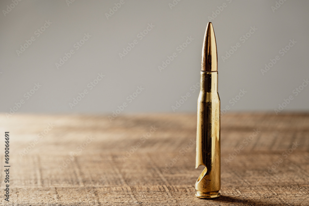 Bottle opener made from brass bullet on wooden table, closeup, copy space - obrazy, fototapety, plakaty 