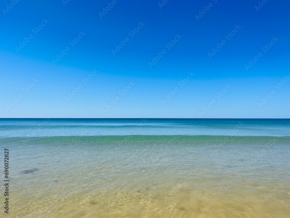 Calm blue ocean horizon, clear blue sky, sea surface background