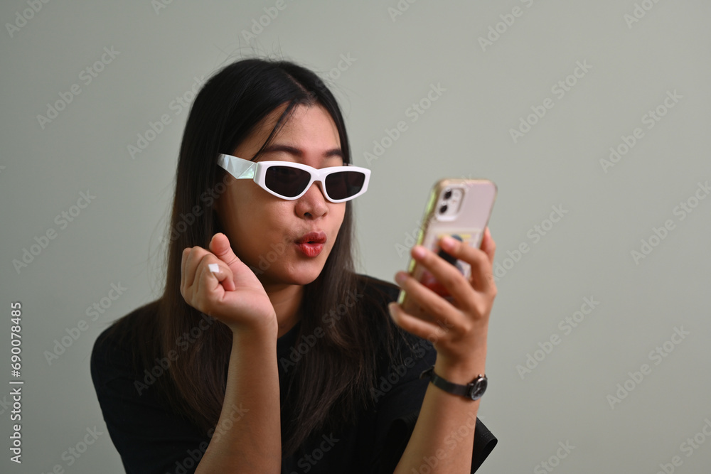 Surprised woman looking at mobile phone screen, received good news notification Surprised woman looking at mobile phone screen, received good news notification