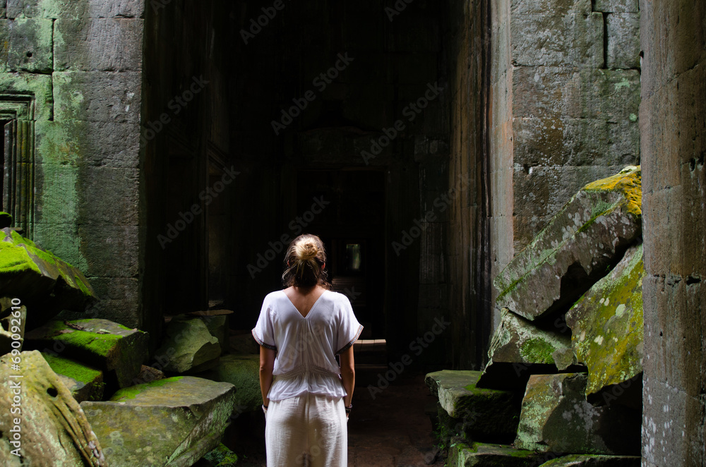 Unrecognizable European Tourist Woman Contemplating The Greatness Of The Ruins Of Angkor Wat In Ta Prohm Temple