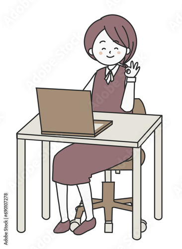 パソコンの前でOKのポーズをする女性