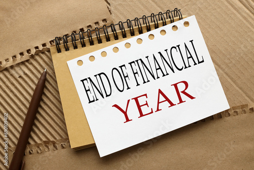 End of Financial Year text. craft notebook on a craft background. text on white page photo