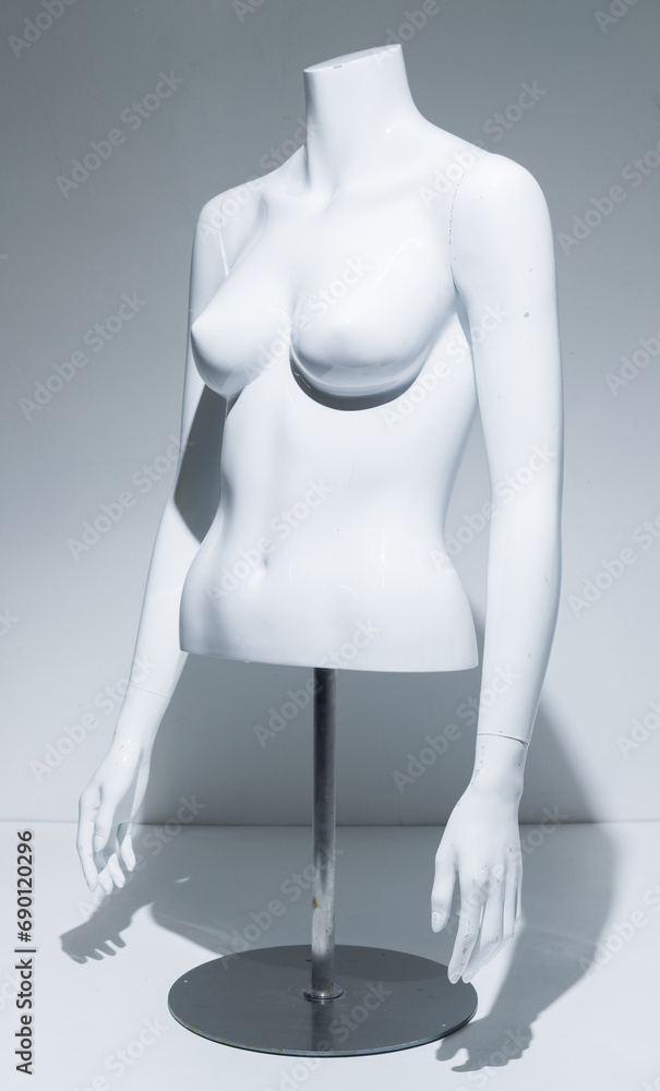 Naklejka premium A Female Mannequin Torso With adjustable arms Arms, gloss White Chest . Bust Display on metal pole and base. Fashion model for retail stores to show off clothing. Retail displays.