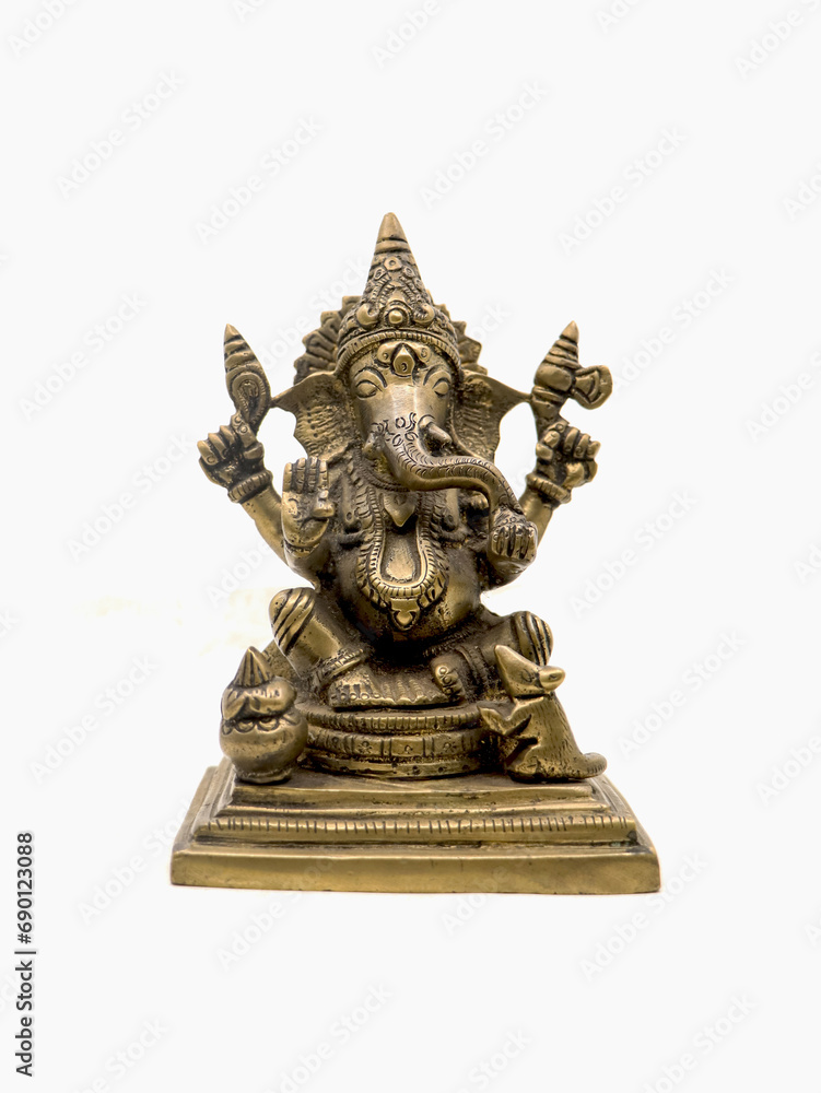 front view of sitting ganesh with four hands, brass statue with intricate details and decorative carvings isolated in a white background 