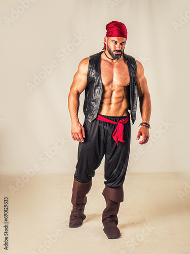 A muscular topless man with a red bandanna and pirate costume, standing in front of a white background photo