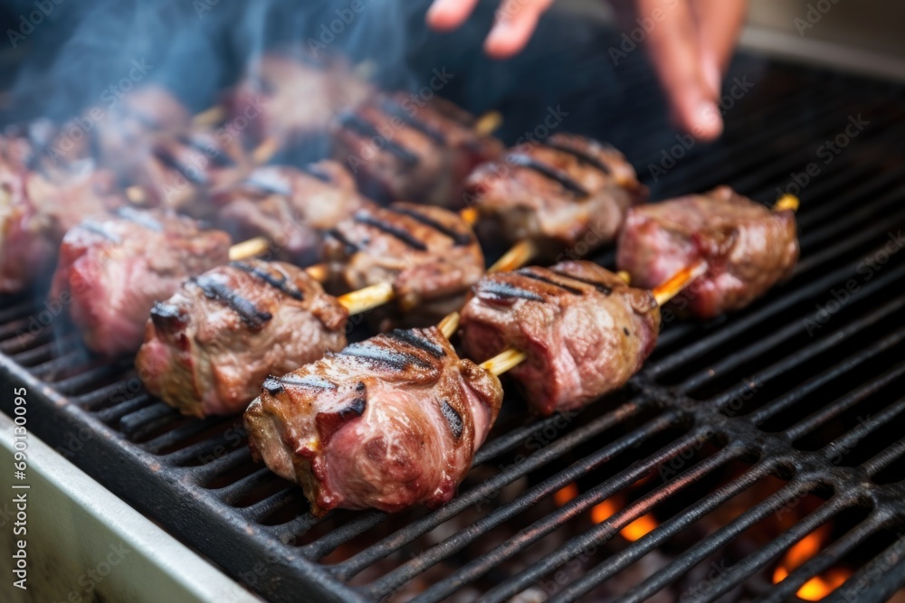 lamb chops on a barbecue grill being checked for doneness