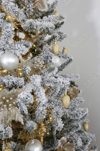 Elegant Christmas tree with white toys and gift boxes in the bedroom of luxury apartments