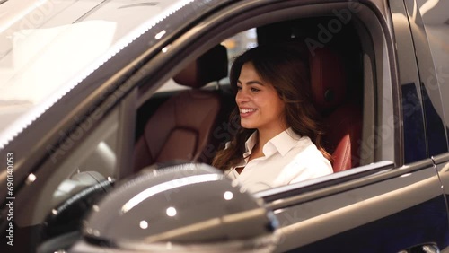 Beautiful woman trying a car she's just bought