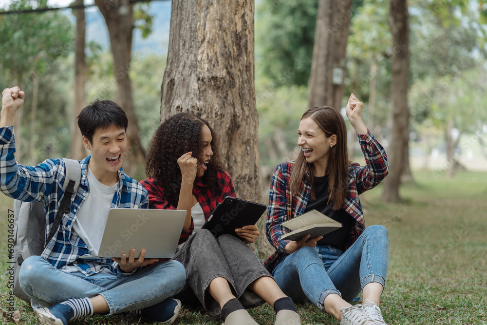 Happy group of college students use laptop feel excited overjoyed triumph with good news over smartphone or Tablet. Happy group of college students use laptop feel excited overjoyed triumph with good news over smartphone or Tablet.