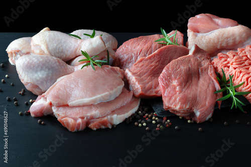Different types of raw meat - beef, pork, lamb, chicken on a wooden board photo
