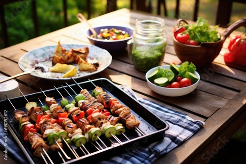 a picnic spread featuring freshly grilled skewers
