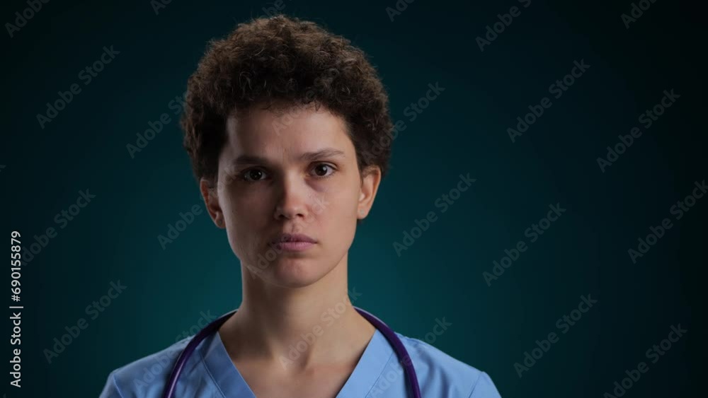 Medical Doctor looking at camera, serious face. on a black background Medical Doctor looking at camera, serious face. on a black background