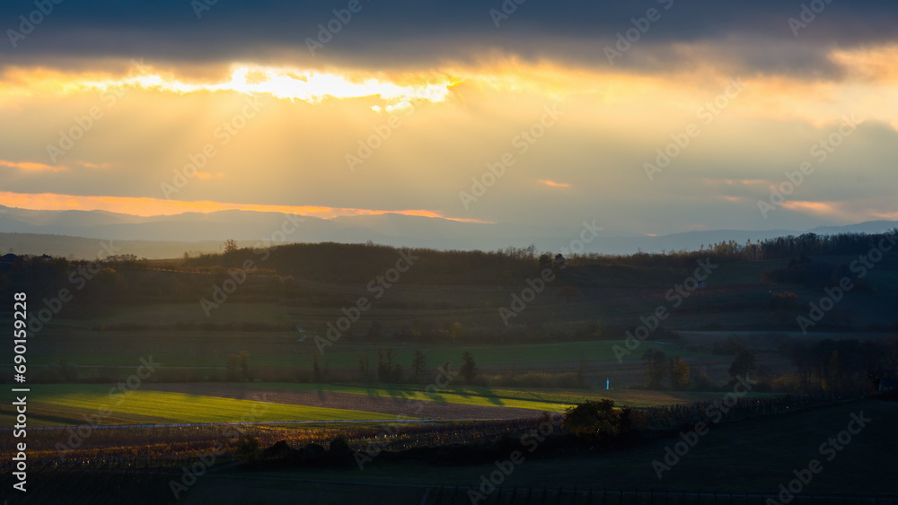 Dramatic clouds at sunset in Burgenland with field in the foreground Dramatic clouds at sunset in Burgenland with field in the foreground