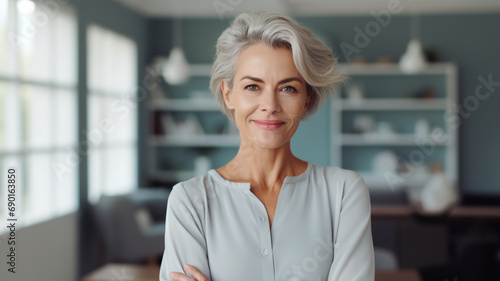 Smiling confident stylish mature middle aged woman standing at home office.