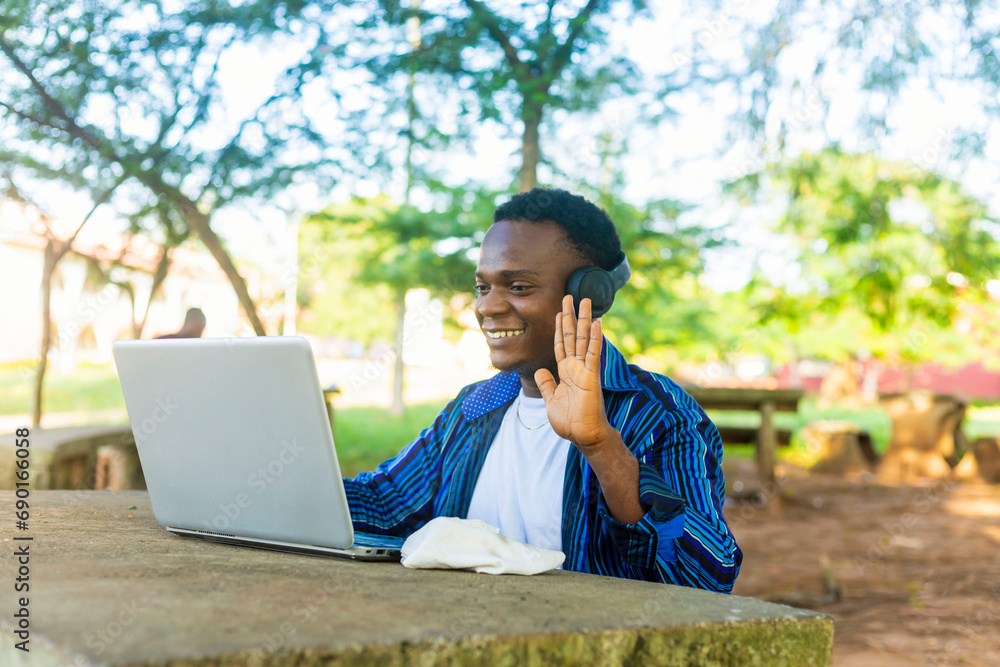 handsome male student on headphone using laptop for distant learning handsome male student on headphone using laptop for distant learning