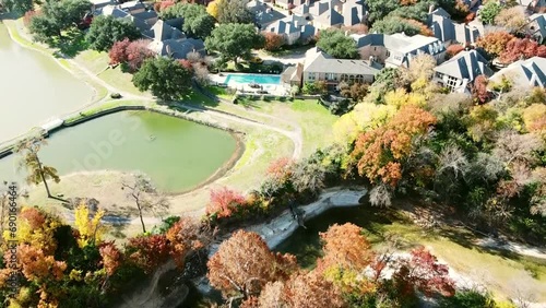 Aerial view lakeside house surrounding colorful fall foliage in Park Central, North Dallas, Texas, upscale waterfront suburban residential homes mature trees, upper class affluent neighborhood photo