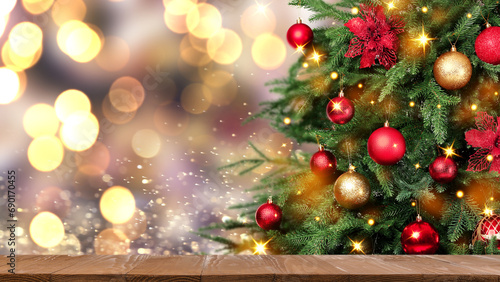 Christmas tree decorated with red and golden balls near wooden table against blurred background. Banner design with space for text