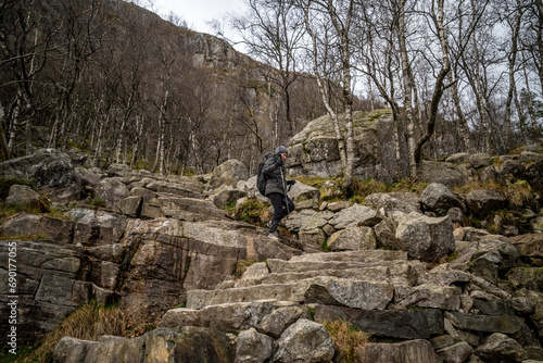 a hiker girl with trekking sticks on a stone staircase