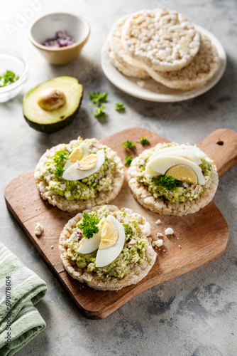 Avocado tuna salad on rice cakes with red onions and boiled egg. 