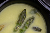 Green spring pureed asparagus soup served in plates