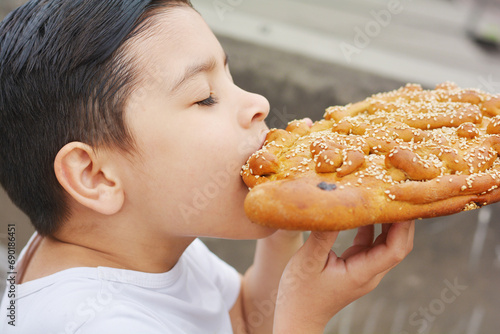 Latin kid with typical big sweet bread named tantawawa for All Saints Day.