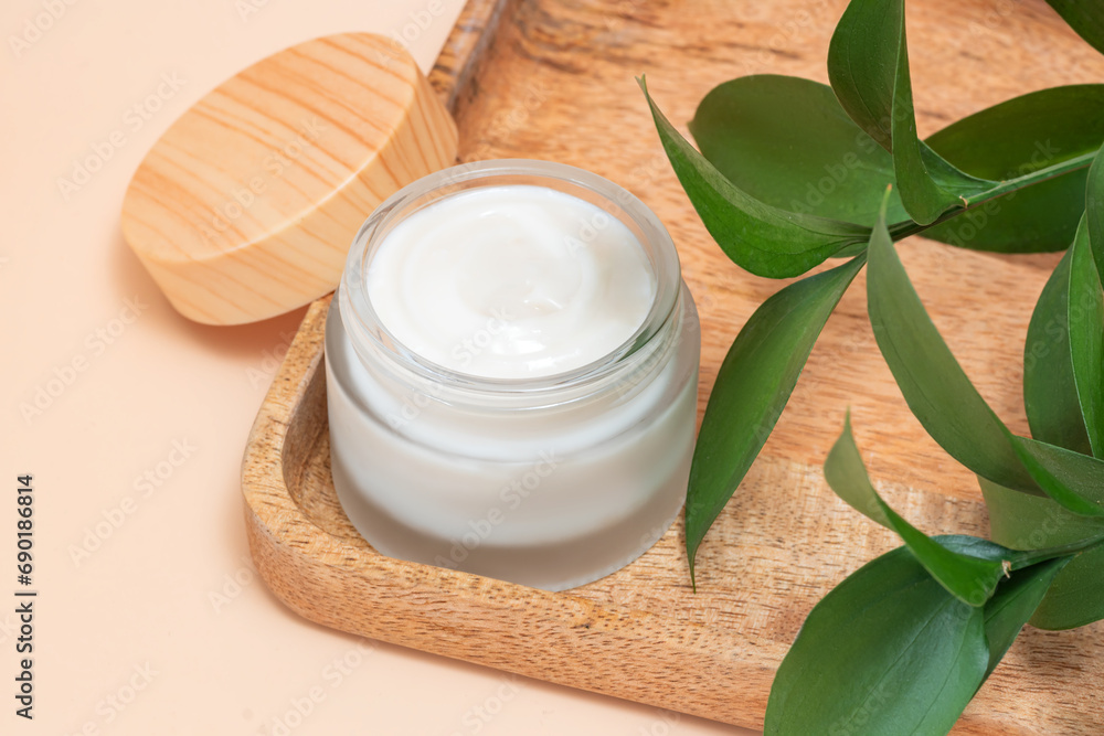 Moisturizer cream jar in matte glass bottle and green leaves on beige background. Cosmetics for skin and body care beauty products Moisturizer cream jar in matte glass bottle and green leaves on beige background. Cosmetics for skin and body care beauty products