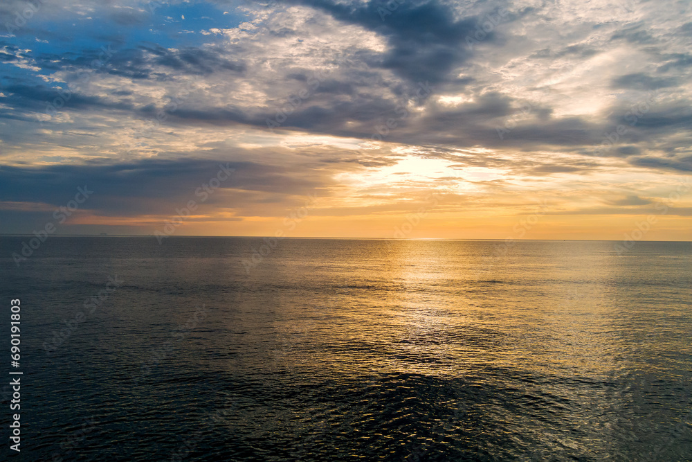 In morning sun rises over water waves of ocean In morning sun rises over water waves of ocean