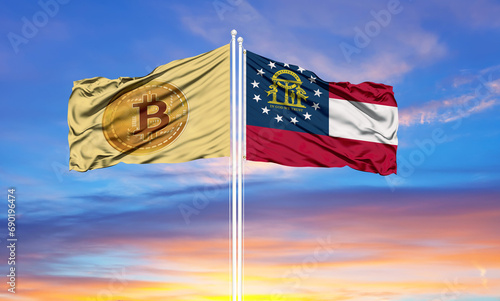 Bitcoin and Georgia two flags on flagpoles and blue sky. photo