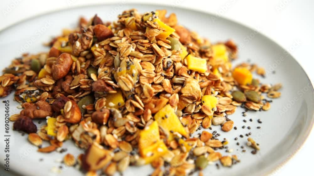 Healthy organic granola breakfast flakes with almonds, cashew nuts walnuts, hazelnuts, pumpkin seeds and cranberries circle rotation close up top view. Healthy organic granola breakfast flakes with almonds, cashew nuts walnuts, hazelnuts, pumpkin seeds and cranberries circle rotation close up top view.