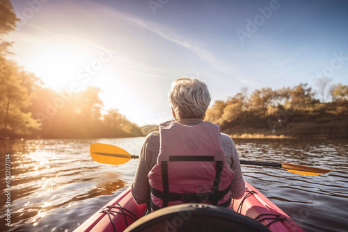 Senior woman kayaking in the river. Healthy elders enjoying summer day outdoors. Sportive people having fun at the nature. Active retirement concept.