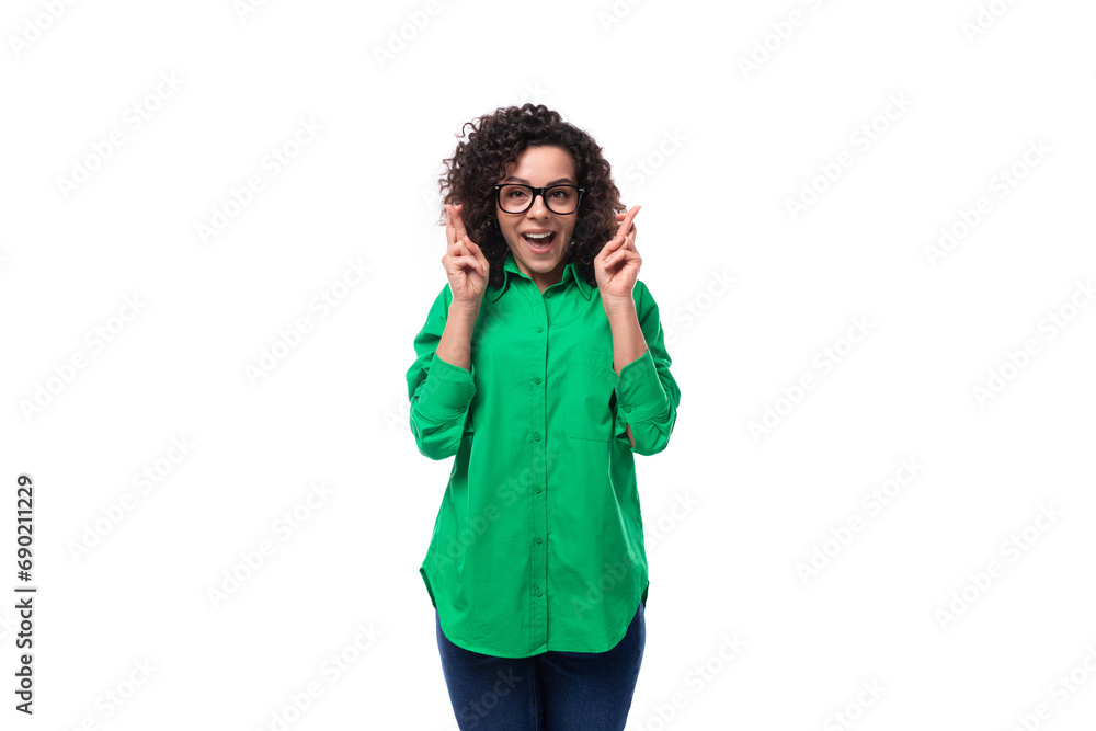 young positive secretary brunette woman with curly hair dressed in a green blouse crossed her fingers and waits for a miracle young positive secretary brunette woman with curly hair dressed in a green blouse crossed her fingers and waits for a miracle