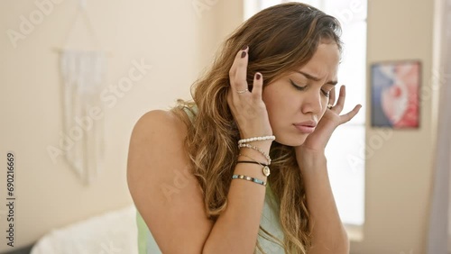 At home, a young, beautiful hispanic woman in casual clothes covers ears with fingers, annoyed by the noise of loud music. deafening sound sparks stress and headache.