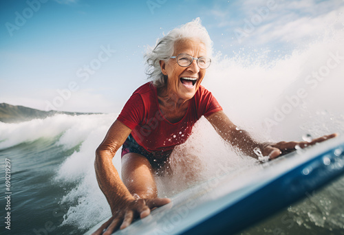 fit senior women having fun surfing Sporty woman training with surfboard on the beach