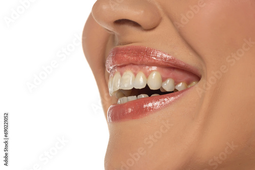 Close-up  side view of a woman s mouth  capturing a confident smile and perfect natural teeth and lips on white background