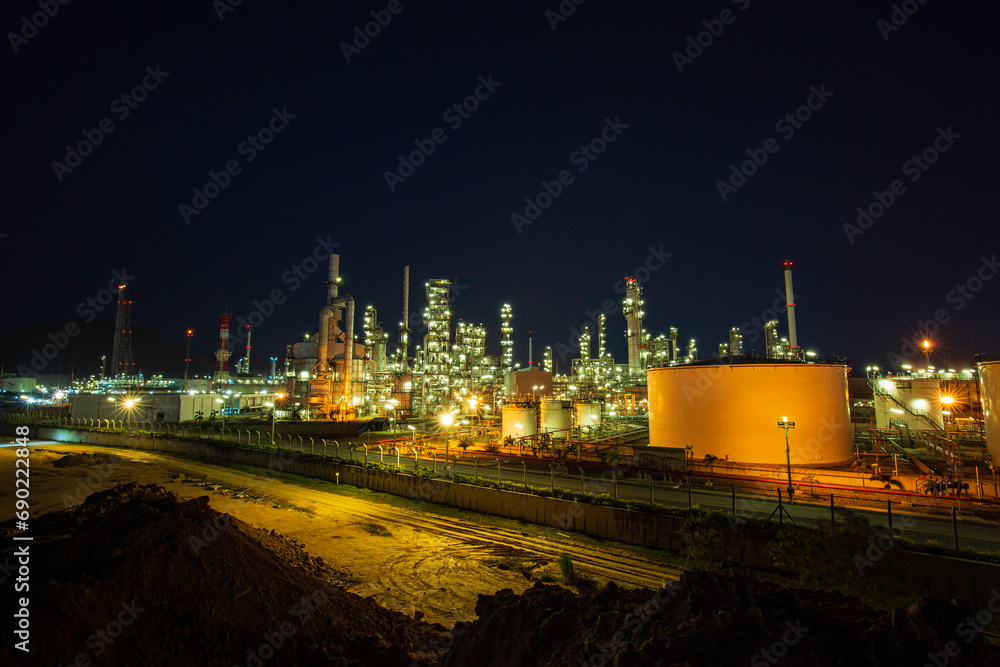 Fototapeta premium Night scene of oil refinery plant and storage white tank oil of Petrochemistry industry