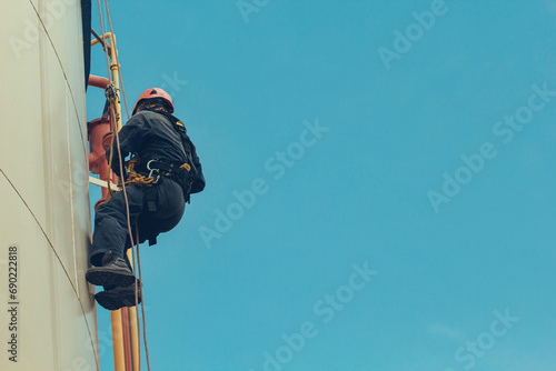 Male worker rope access height safety inspection of thickness storage oil and gas tank photo
