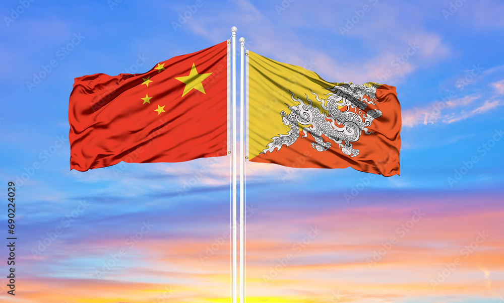 Flag of China and Bhutan waving in the wind against white cloudy blue sky together. Diplomacy concept, international relations