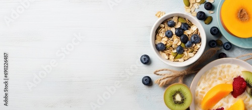 Wallpaper Mural Healthy breakfast with oatmeal porridge fruits and nuts Blueberry mango pumpkin seeds nuts coffee cup Top view Female hands. Website header. Creative Banner. Copyspace image Torontodigital.ca