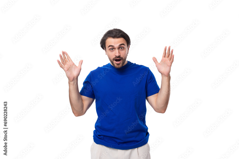 young brunette man with a beard dressed in a blue t-shirt thinks about solving problems on a white background young brunette man with a beard dressed in a blue t-shirt thinks about solving problems on a white background
