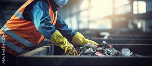 Hands in gloves of a uniformed employee sort garbage into categories on a special line at a waste recycling plant. Website header. Creative Banner. Copyspace image