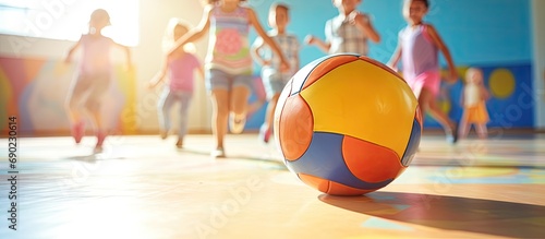 Group of kids has fun playing ball in physical education class in elementary school or day care center. Website header. Creative Banner. Copyspace image photo