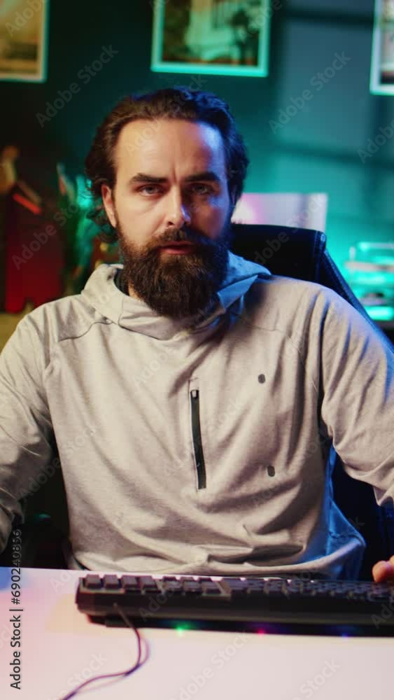 Vertical video Man plays intense videogame tournament online during stream with audience, spamming attack buttons. Gamer participating in esports competition during livestream, pressing hard on Vertical video Man plays intense videogame tournament online during stream with audience, spamming attack buttons. Gamer participating in esports competition during livestream, pressing hard on